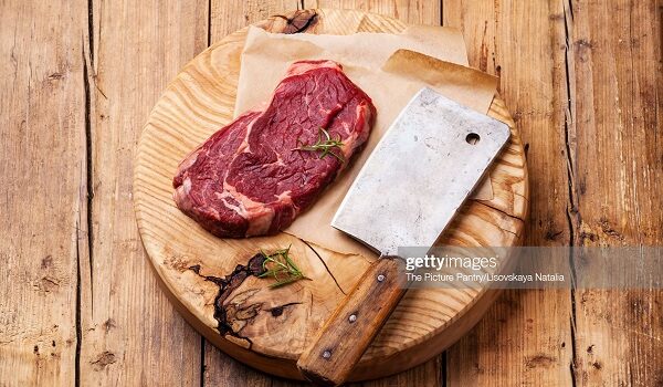 Raw fresh meat Ribeye Steak and meat cleaver on wooden background