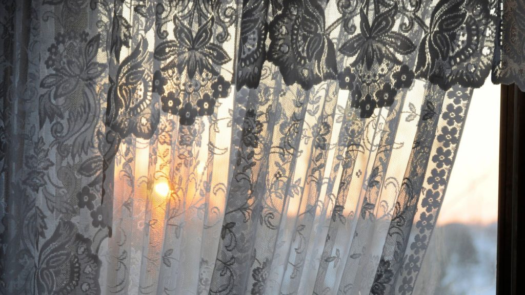 sunset through ornate window treatment